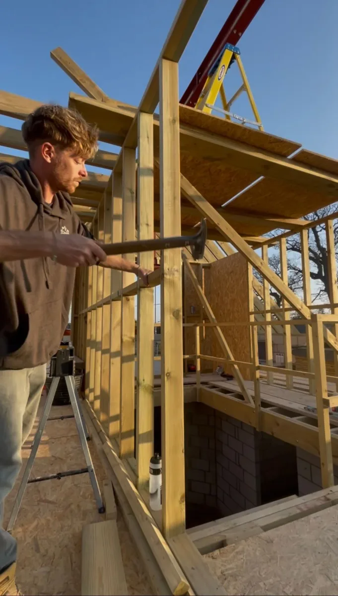 Curtis Etheridge, director of Etheridge Construction, fixing a timber stud wall frame on site