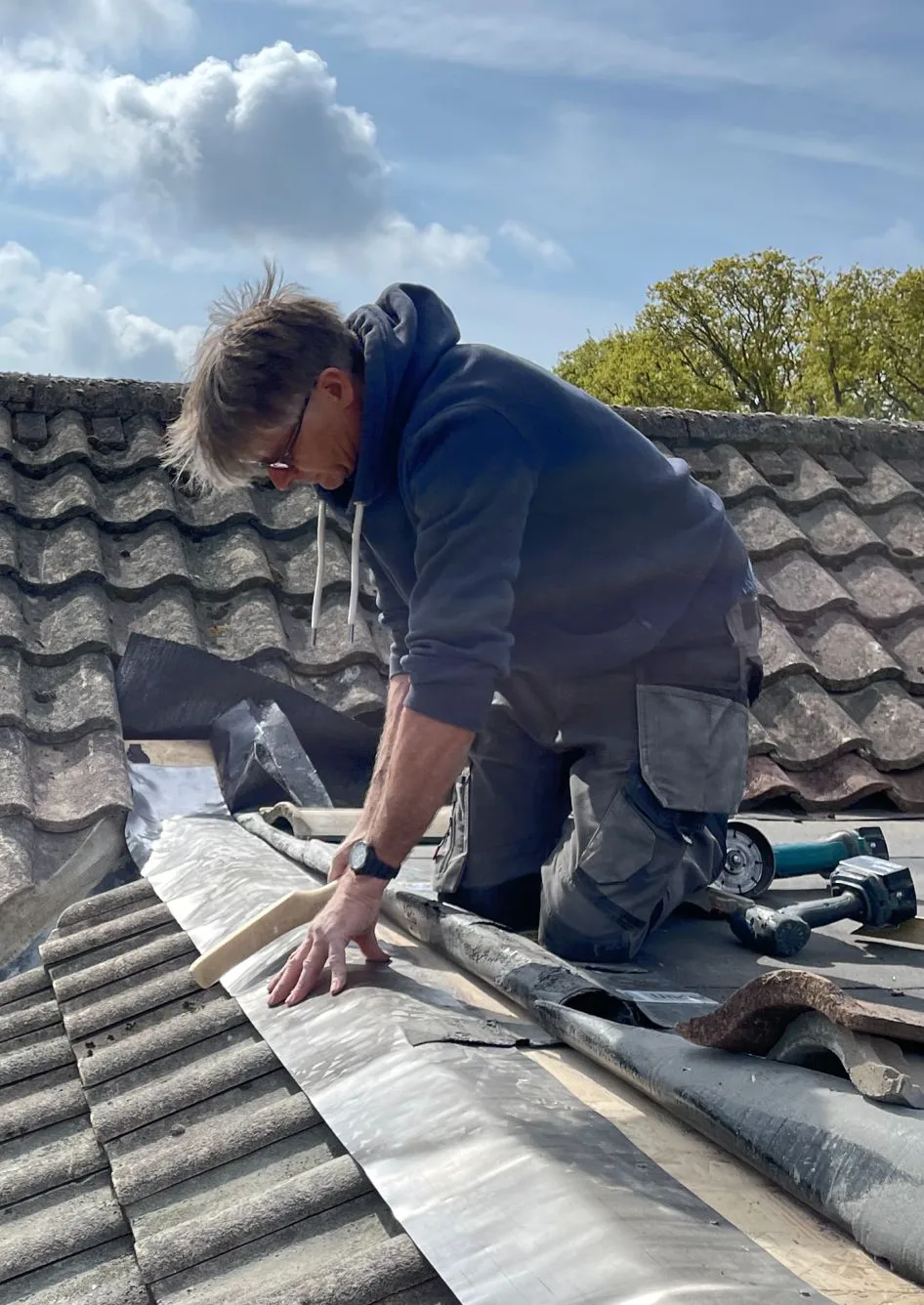 John Etheridge, founder of Etheridge Construction, dressing lead flashing on a tiled roof